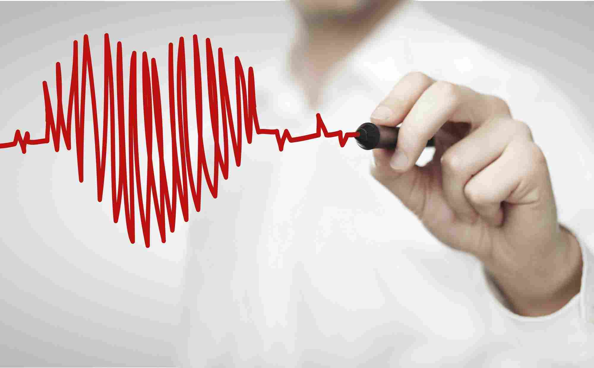 Ruka flomasterom crta EKG liniju u obliku srca